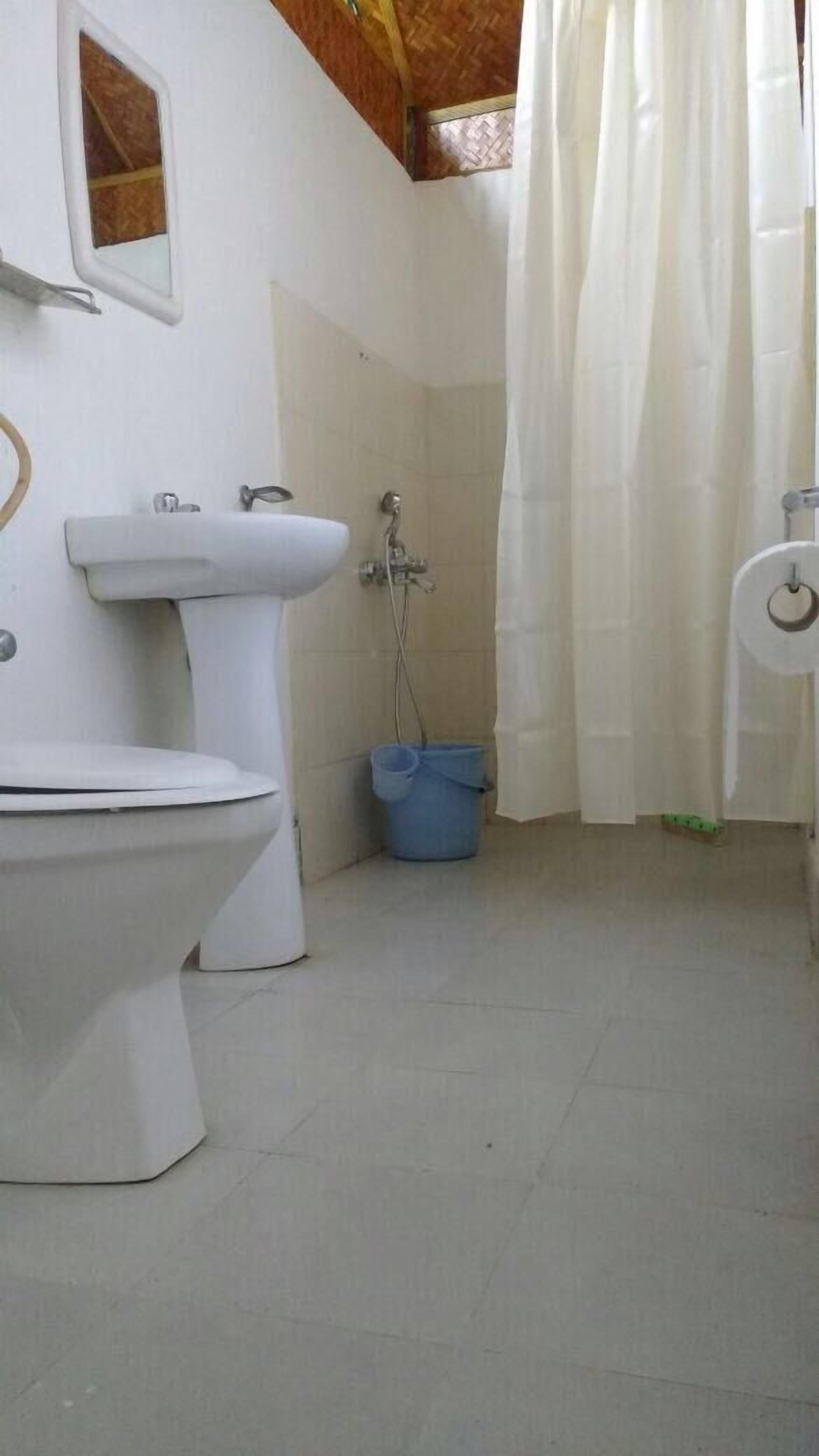 A bathroom with a toilet, sink, and shower area.