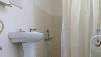 Une salle de bain comprenant des toilettes, un lavabo et un espace douche.