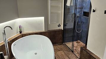 Habitación Deluxe | Baño | Bañera profunda, cabezal de ducha tipo lluvia, secador de pelo y bidé