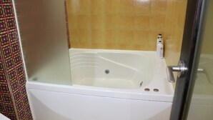 Ein Badezimmer mit Badewanne, Dusche und Toilette.