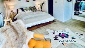Ein Schlafzimmer mit Bett, Stuhl, Teppich und Spiegel.