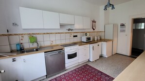 A compact kitchen with white cabinets, a microwave, a sink, and a dishwasher. - Spacious vacation home on 19 hectares of woodland in a secluded location (Gerdau)