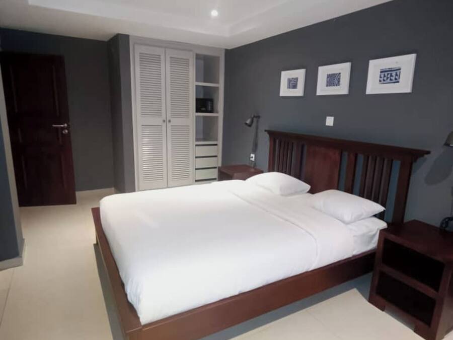 A bedroom with a wooden bed, a wardrobe, and a nightstand.