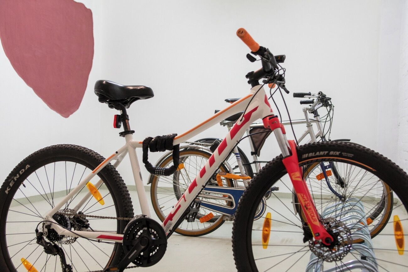 En hvid mountainbike med røde og orange detaljer, et sort sæde og en forgaffel med affjedring.