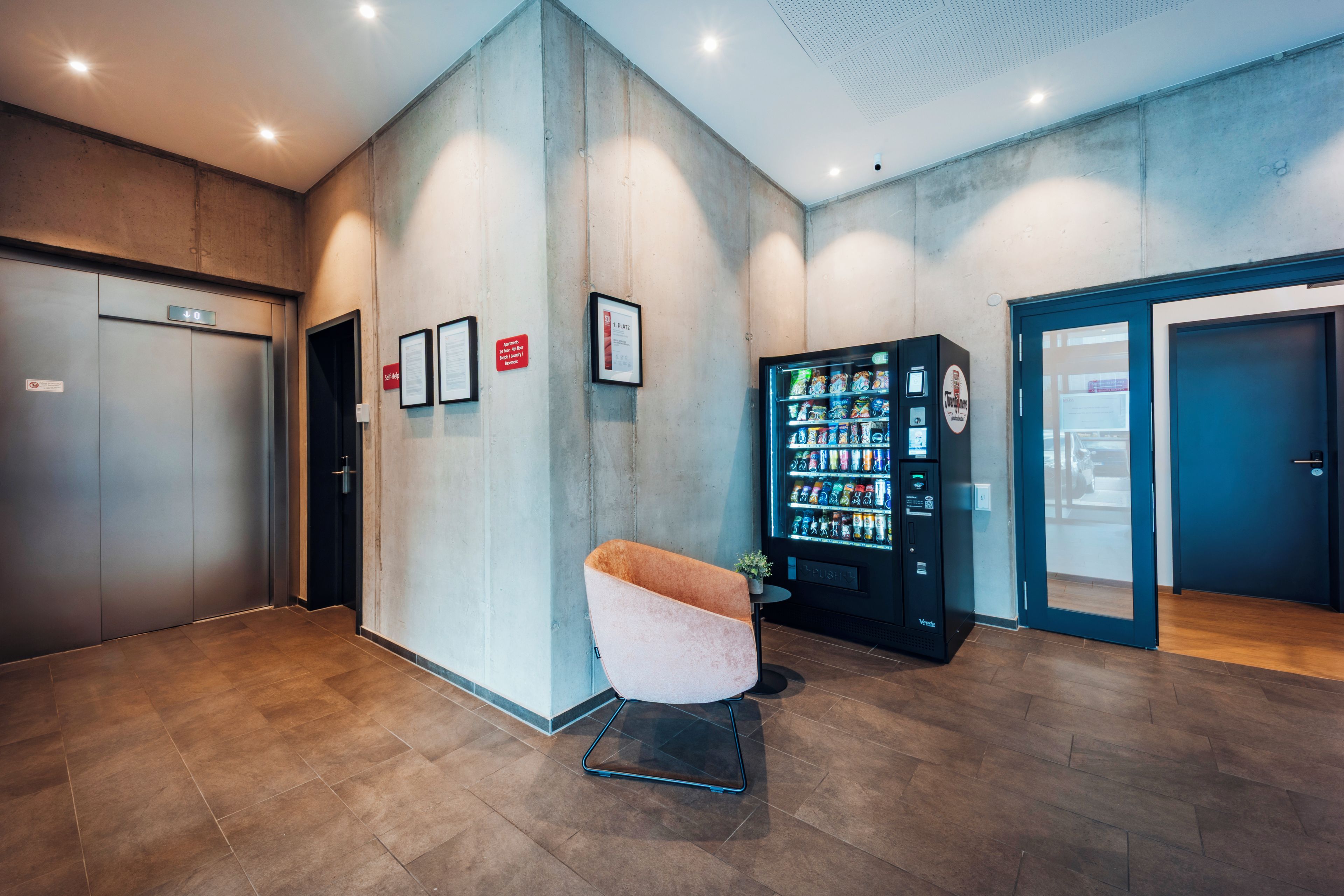 Un hall d’entrée moderne équipé d’un distributeur automatique, d’un espace détente et d’un comptoir d’accueil.