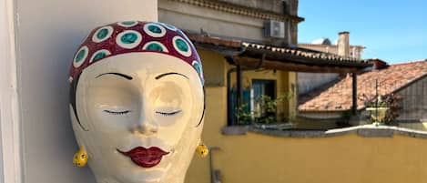 Un bust decoratiu amb una peça de cap amb dibuixos sobre una barana de balcó.
