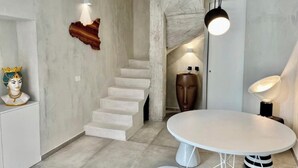Een modern interieur met een trap, een ronde tafel en een borstbeeld.