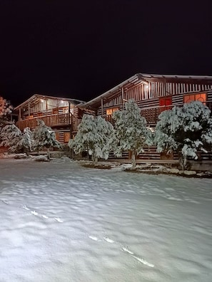 A wooden lodge with a snow-covered landscape at night. - Room-parador Arewá 1 La Energía Que Impu (Bocoyna)