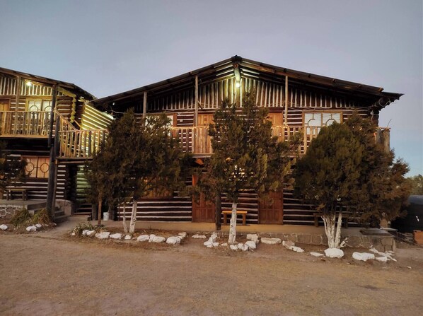A log cabin with a balcony and a stone foundation. - Room-parador Arewá 1 La Energía Que Impu (Bocoyna)