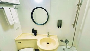 Ein Badezimmer mit Waschbecken, Spiegel, Toilette und Dusche.
