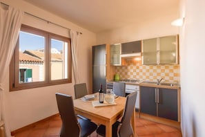 Une cuisine de taille réduite avec une table à manger, des chaises et une vue sur l’extérieur.