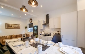 Enjoy meals and relaxation in this stylish dining area with a contemporary kitchen and comfortable seating.