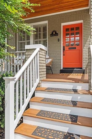 A wooden staircase leading to a red door with a window, white railings, and a brick wall. - 402 House in Heart Historic Old Town, Walk to King St, Water, Shops, Metro & DMV (Alexandria)