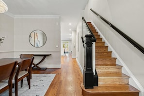 A staircase with wooden steps and a black handrail, leading to a second-floor landing. - 402 House in Heart Historic Old Town, Walk to King St, Water, Shops, Metro & DMV (Alexandria)