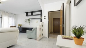 A modern living room with a sofa, a coffee table, and a potted plant. - Casa Giovanna by Wonderful Italy (Bari)