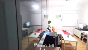 A modern office space with glass partitions, desks, chairs, and two computer monitors. - Room-butler's Bnb B Trees Residences Qc (Quezon City)