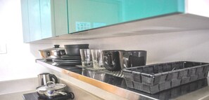 A kitchen with a stainless steel countertop, a coffee maker, and a basket of utensils. - Room-butler's Bnb B Trees Residences Qc (Quezon City)