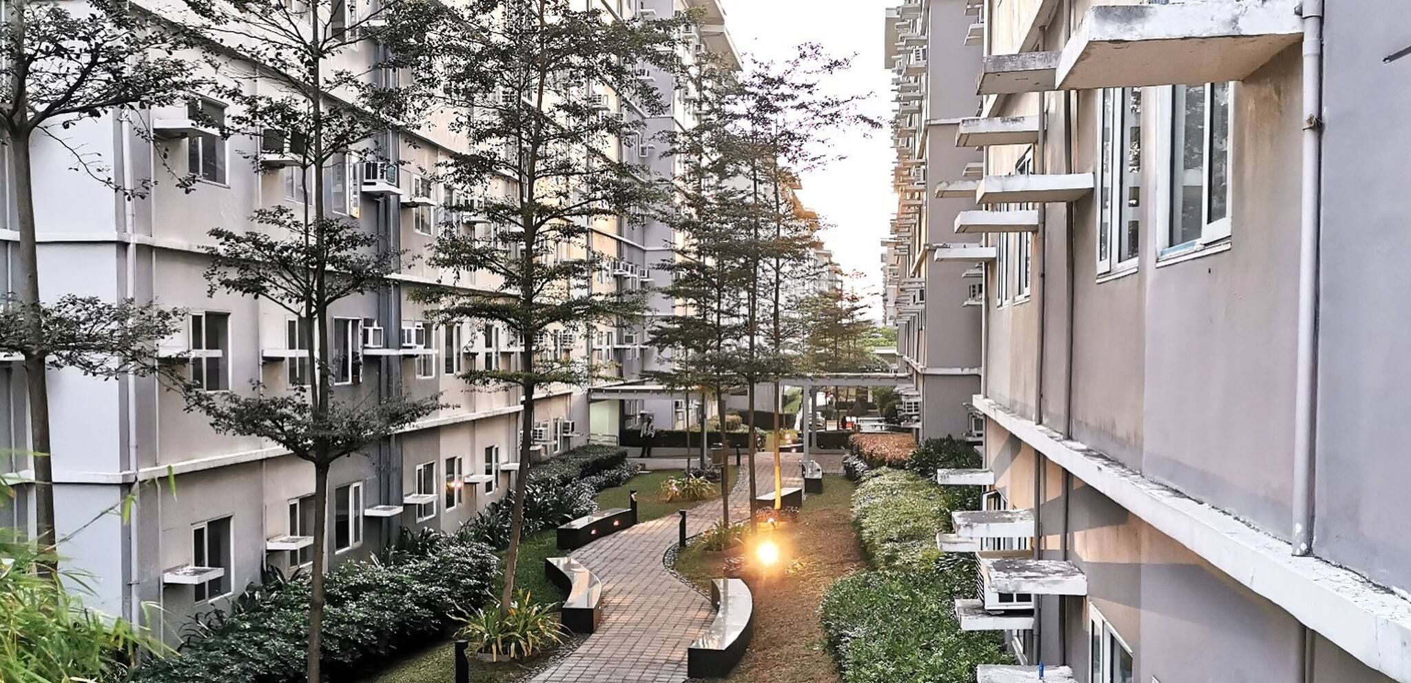 A residential building with multiple balconies and a central pathway.