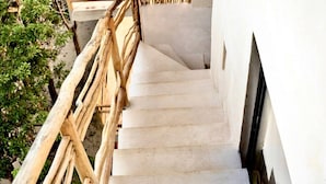 A staircase with a bamboo railing leading to a white wall. - Studio Ph Private Rooftop Pool Great Located (Tulum)