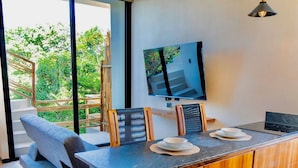A modern kitchen with a central island, wooden cabinets, and a large window offering a view of greenery. - Studio Ph Private Rooftop Pool Great Located (Tulum)