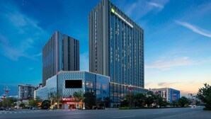 A modern hotel with a prominent vertical design, large glass windows, and a clear sky. - Wyndham Garden Chuxiong Downtown (Chuxiong Yi)