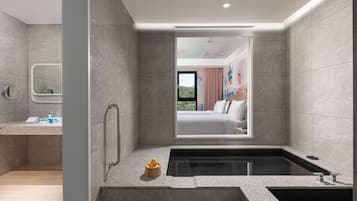 Uma casa de banho moderna com banheira, zona de duche e toucador com espelho.