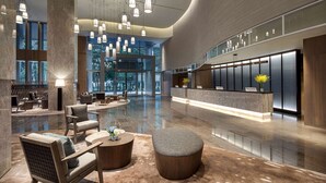 A spacious lobby with a reception desk, seating area, and large windows offering views of the outdoors. - Wyndham Sun Moon Lake (Yuchi)
