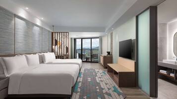 A modern hotel room with a large bed, a TV, a desk, and a balcony with a view.