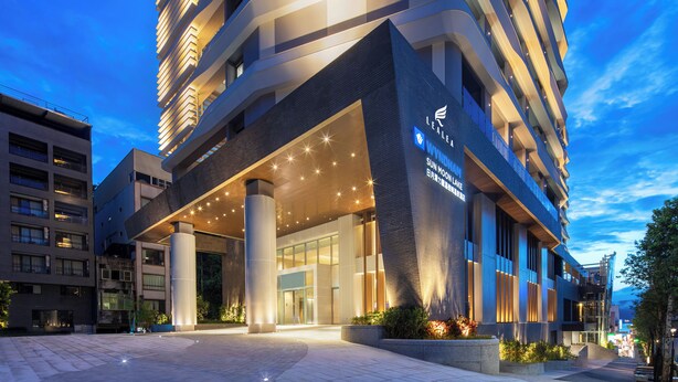A modern hotel with a prominent entrance, large columns, and a well-lit facade. - Wyndham Sun Moon Lake (Yuchi)