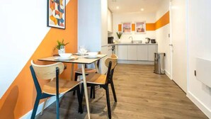 A compact kitchen with white cabinets, a sink, and a small trash bin. - Exquisite 1-bed Homely Apartment in Manchester (Salford)
