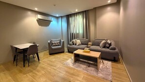 A modern living room with a dining table, two sofas, and a coffee table. - السعاده سويت للشقق المخدومه (Riyadh)