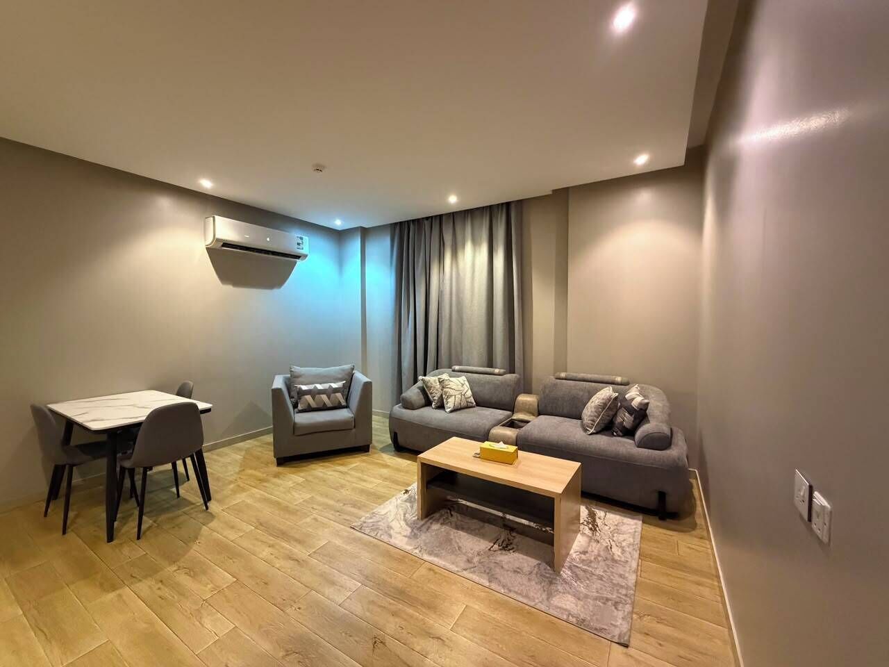 Una sala de estar moderna con una mesa de comedor, dos sofás y una mesa de centro.