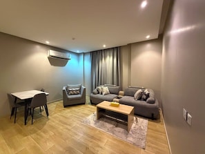 A modern living room with a dining table, two sofas, and a coffee table. - السعاده سويت للشقق المخدومه (Riyadh)