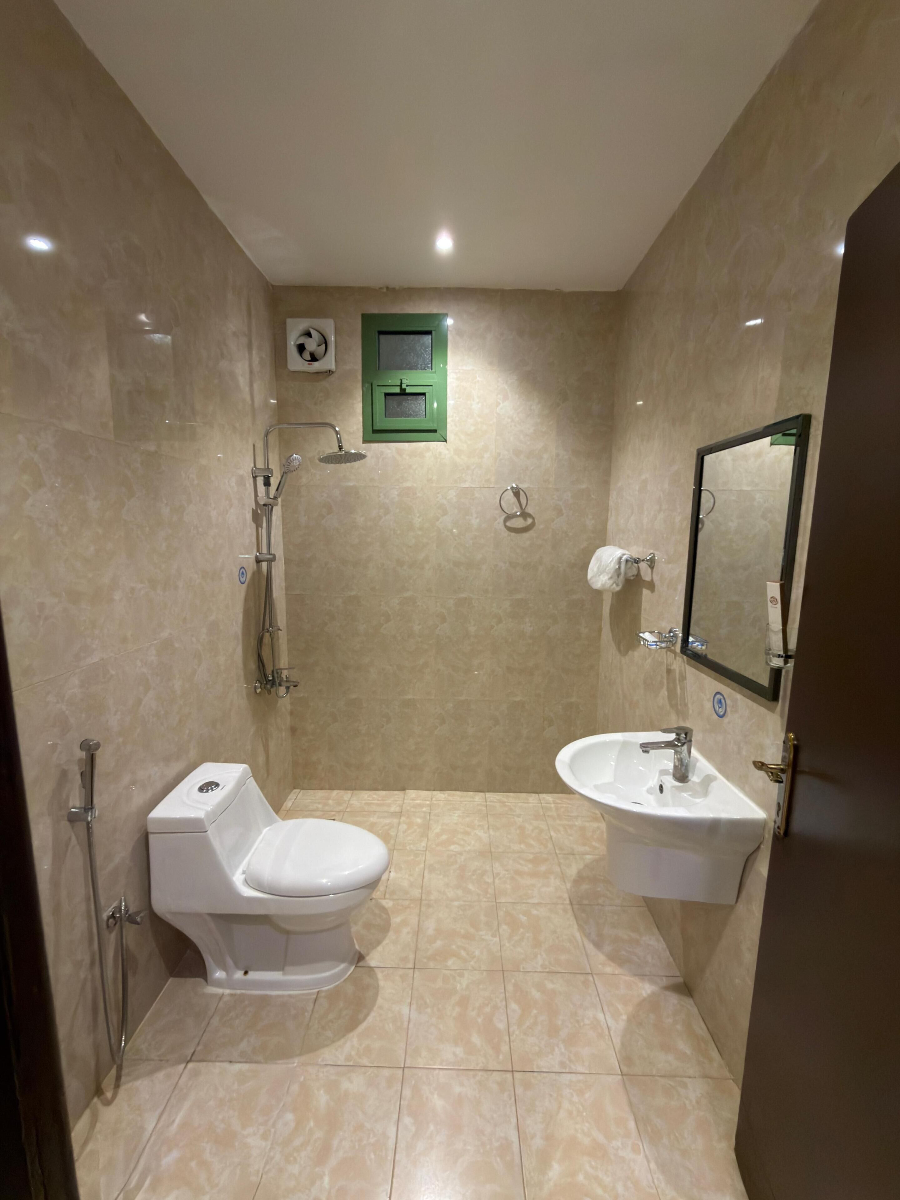 A bathroom with a toilet, sink, and shower.