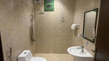 A bathroom with a toilet, sink, and shower.