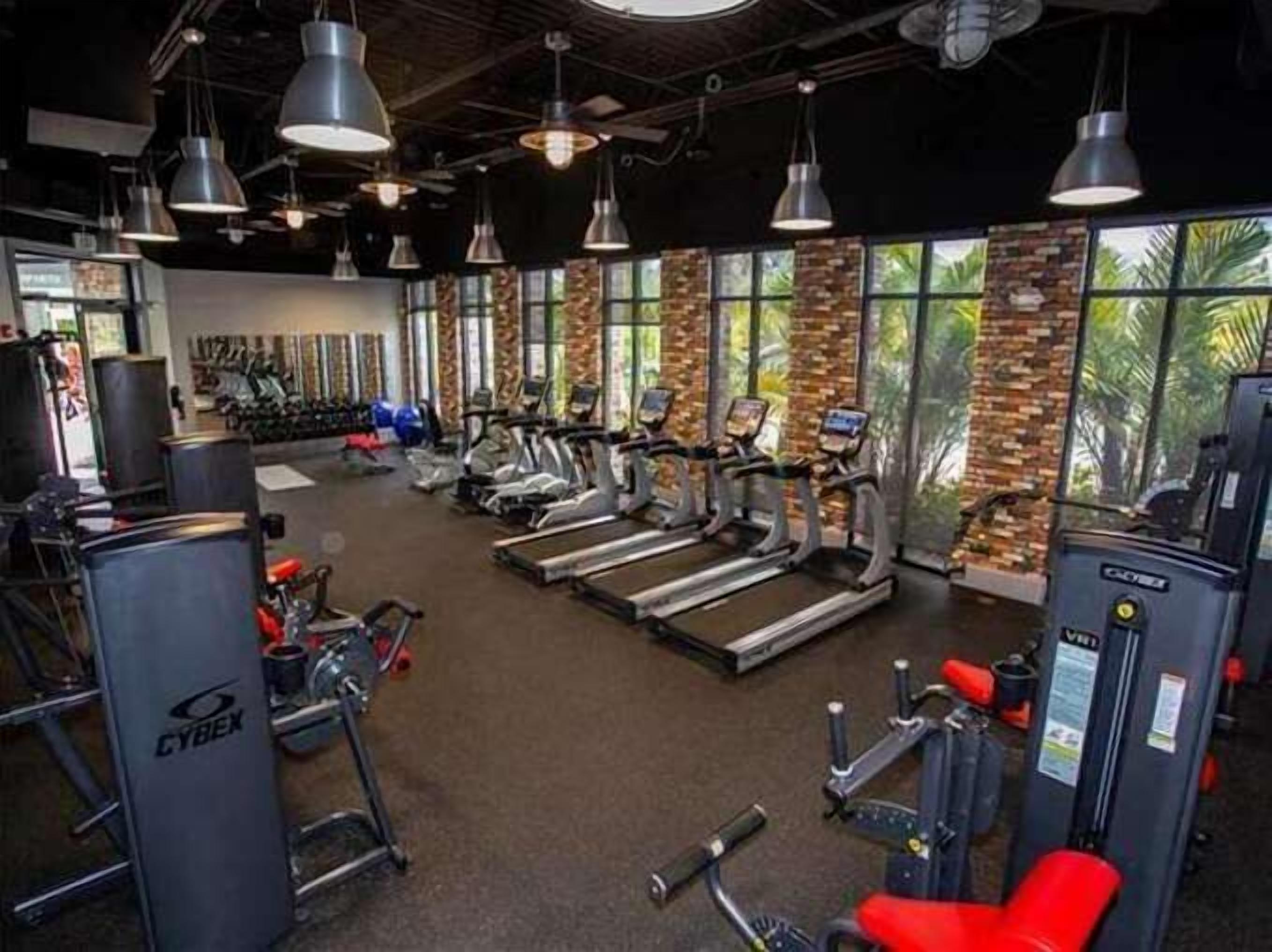 A gym with treadmills, stationary bikes, and weight machines.