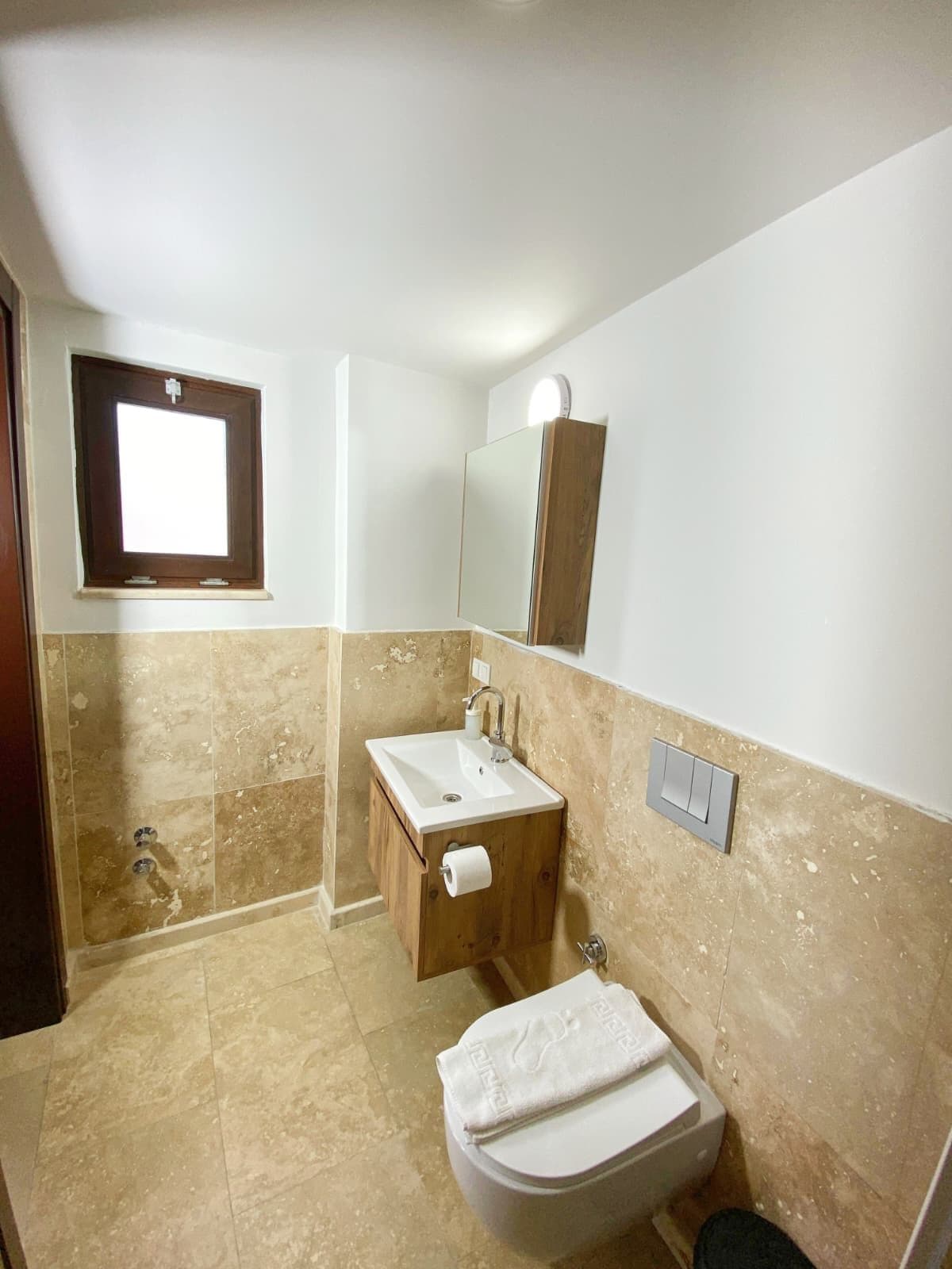 Un baño con inodoro, lavamanos y espejo.