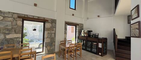 A spacious room with a stone wall, wooden furniture, a bar area, and a staircase.