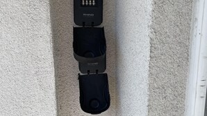 Un dispositif de sécurité fixé au mur, doté d’un mécanisme de verrouillage et d’un câble qui y est raccordé.