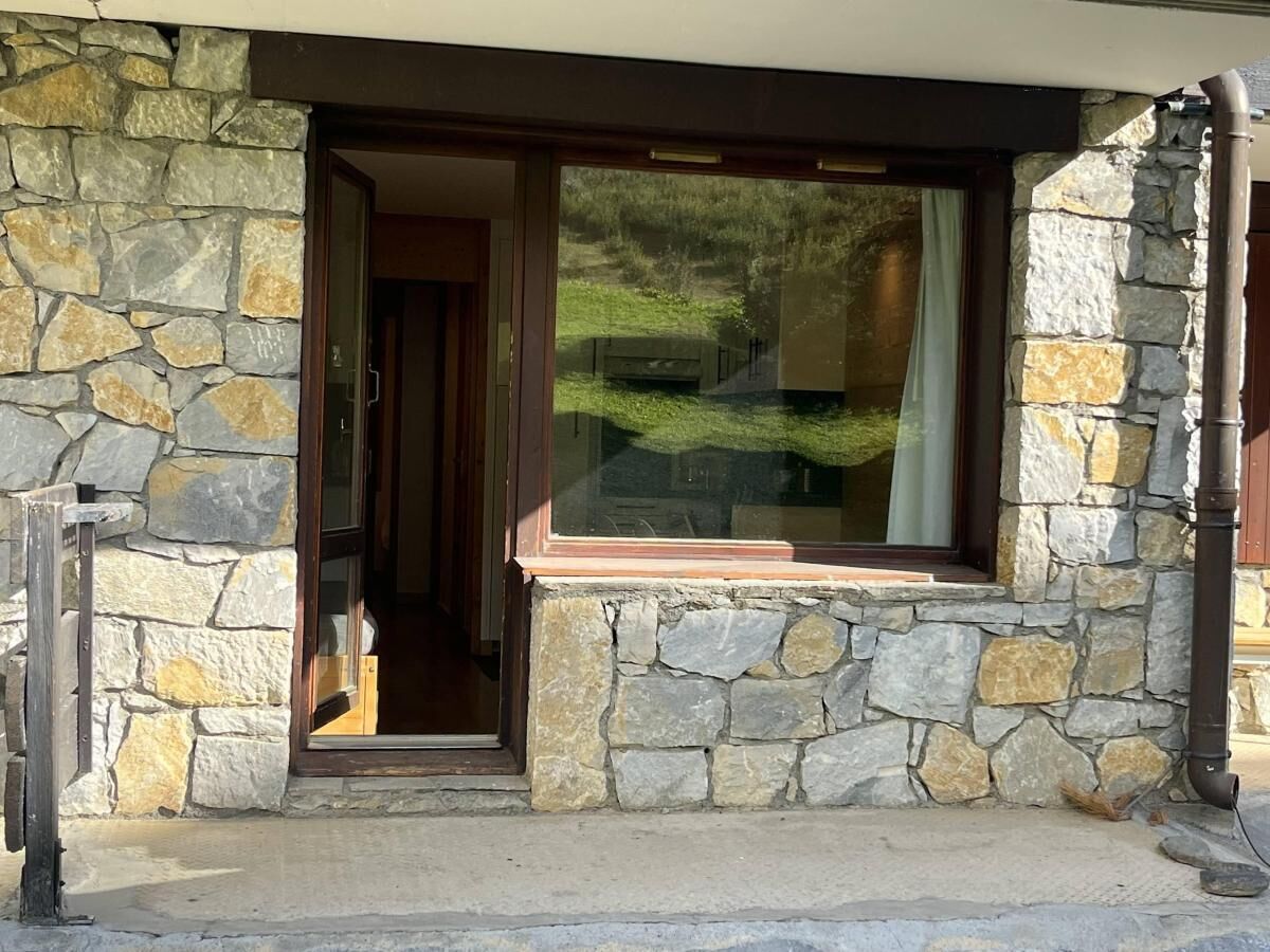 A stone building with a wooden door and a window.