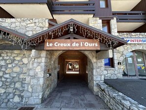 A stone building entrance with a sign reading "Le Creux de l'Ours".
