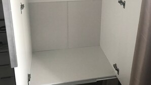 En rymlig klädkammare med en metallstång för att hänga upp kläder och ett platt förvaringsutrymme.