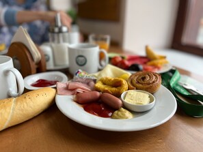 A breakfast plate with various items including bread, sausages, a pastry, and condiments. - Wellness Resort Bouda Malá Úpa (Mala Upa)