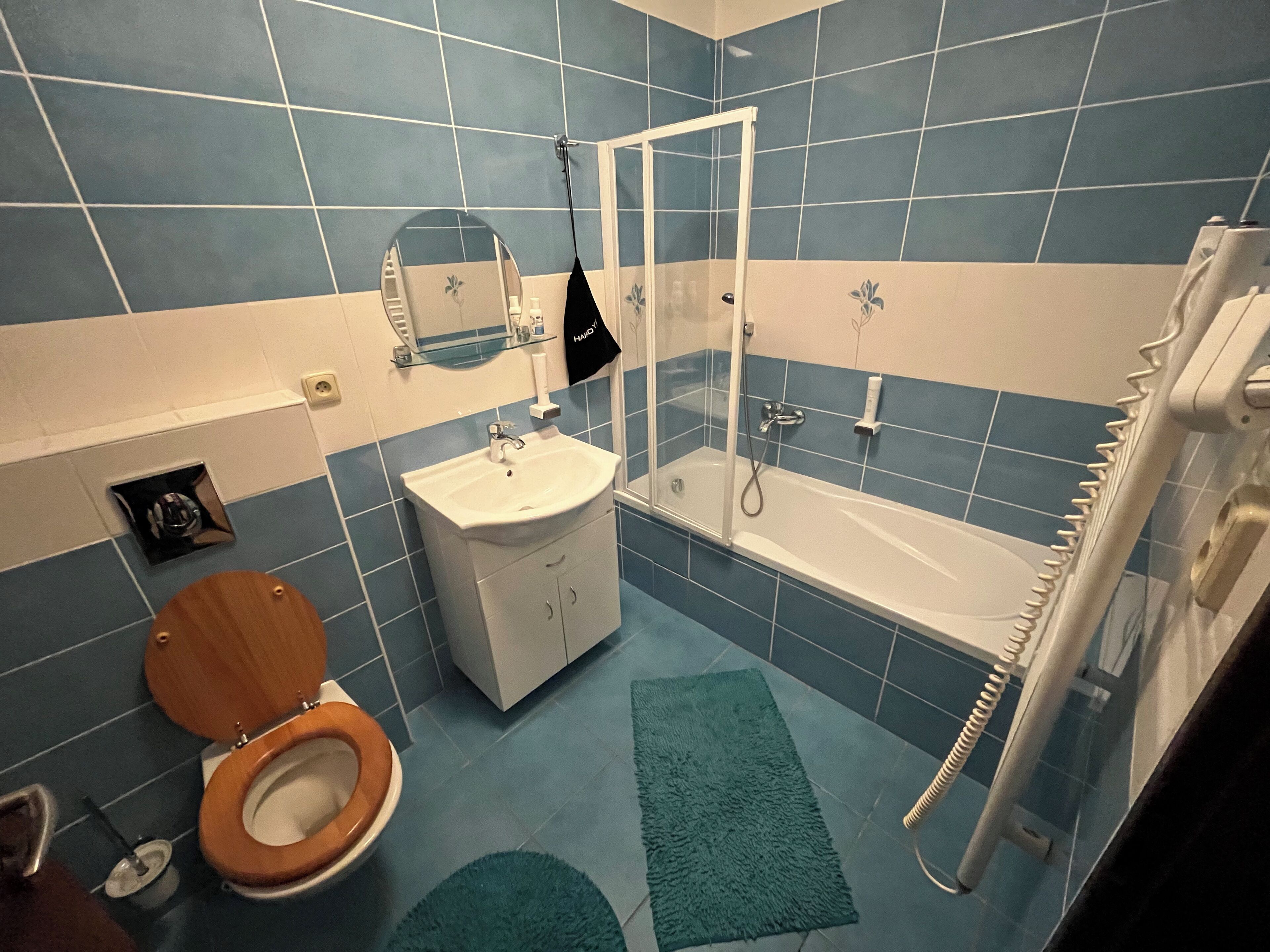 Un baño con inodoro, lavamanos, espejo y bañera.