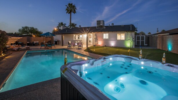 A backyard with a swimming pool, hot tub, and outdoor seating area. - The Oasis - Heated Pool - Spa - Arcade (Scottsdale)