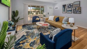 A modern living room with a sofa, chairs, a coffee table, and artwork on the walls. - The Oasis - Heated Pool - Spa - Arcade (Scottsdale)