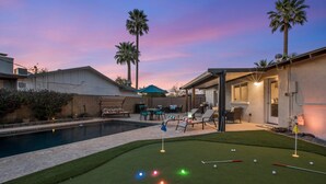 A backyard with a pool, artificial turf, and a putting green. - The Oasis - Heated Pool - Spa - Arcade (Scottsdale)