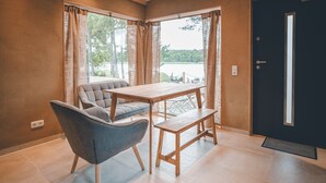 A room with a sofa, a wooden table, and a bench. - Naturcamping Brettmühlenteich e.G. (Thiendorf)