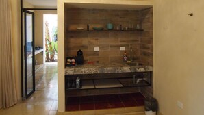 A kitchen with a tiled backsplash, a countertop, and a sink. There is a sliding door leading to a balcony. - Encantadora Suite, en la Mejor Zona de Paseo Montejo. En el Barrio Gastronómico (Mérida)
