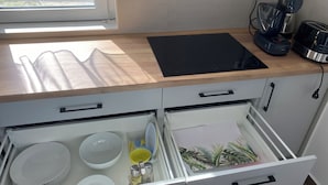A kitchen with a wooden countertop, a black cutting board, a coffee maker, and a toaster. - Vitorlás apartman 2
 (Balatonszárszó)